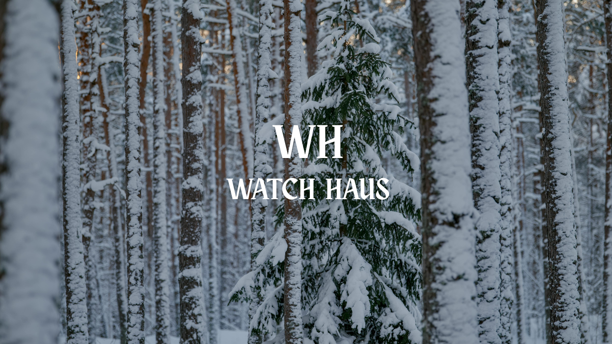 Snow-covered trees in a forest with 'WH Watch Haus' branding.